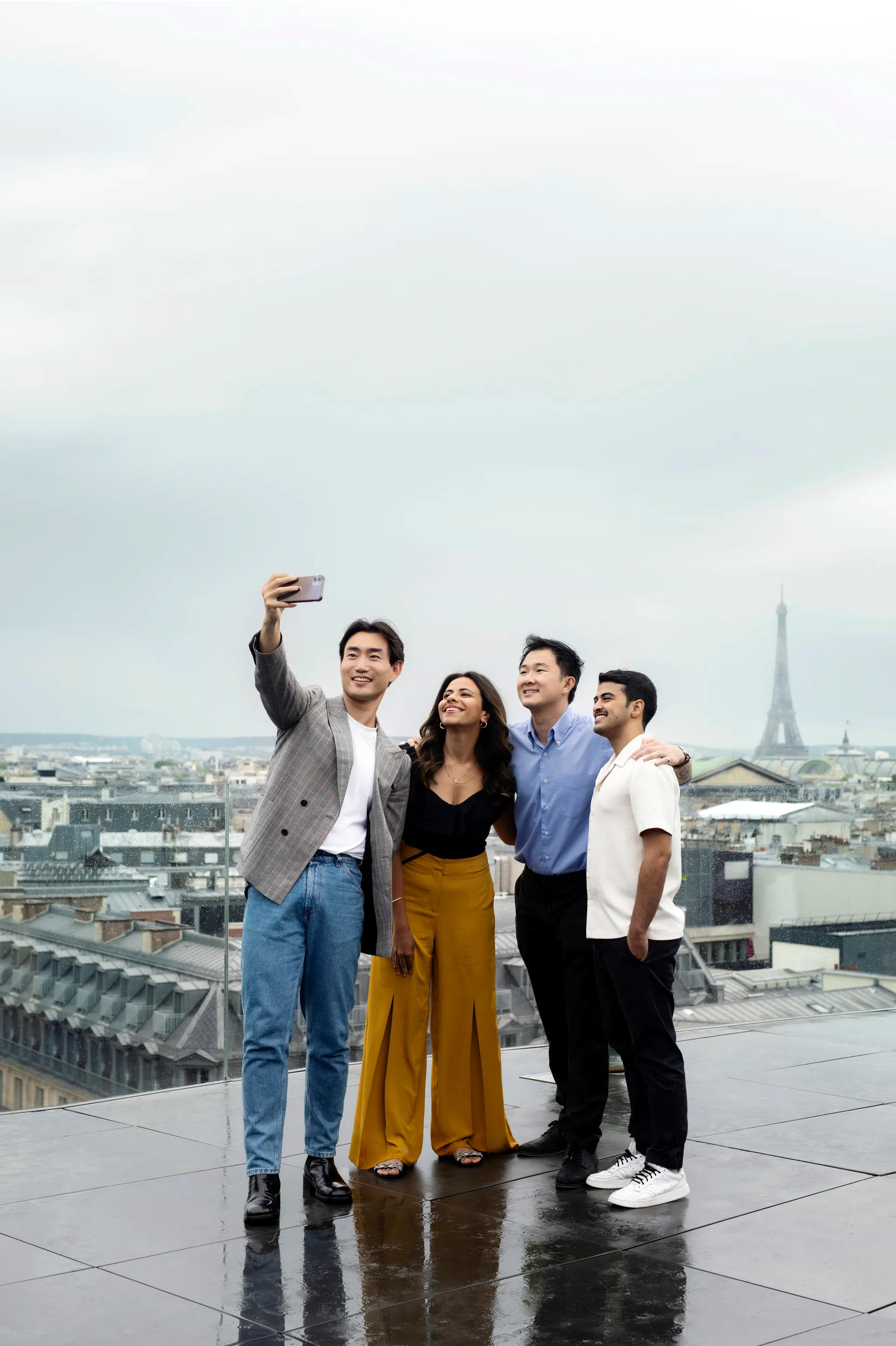 Groupe de jeunes prenant un selfie devant la Tour Eiffel