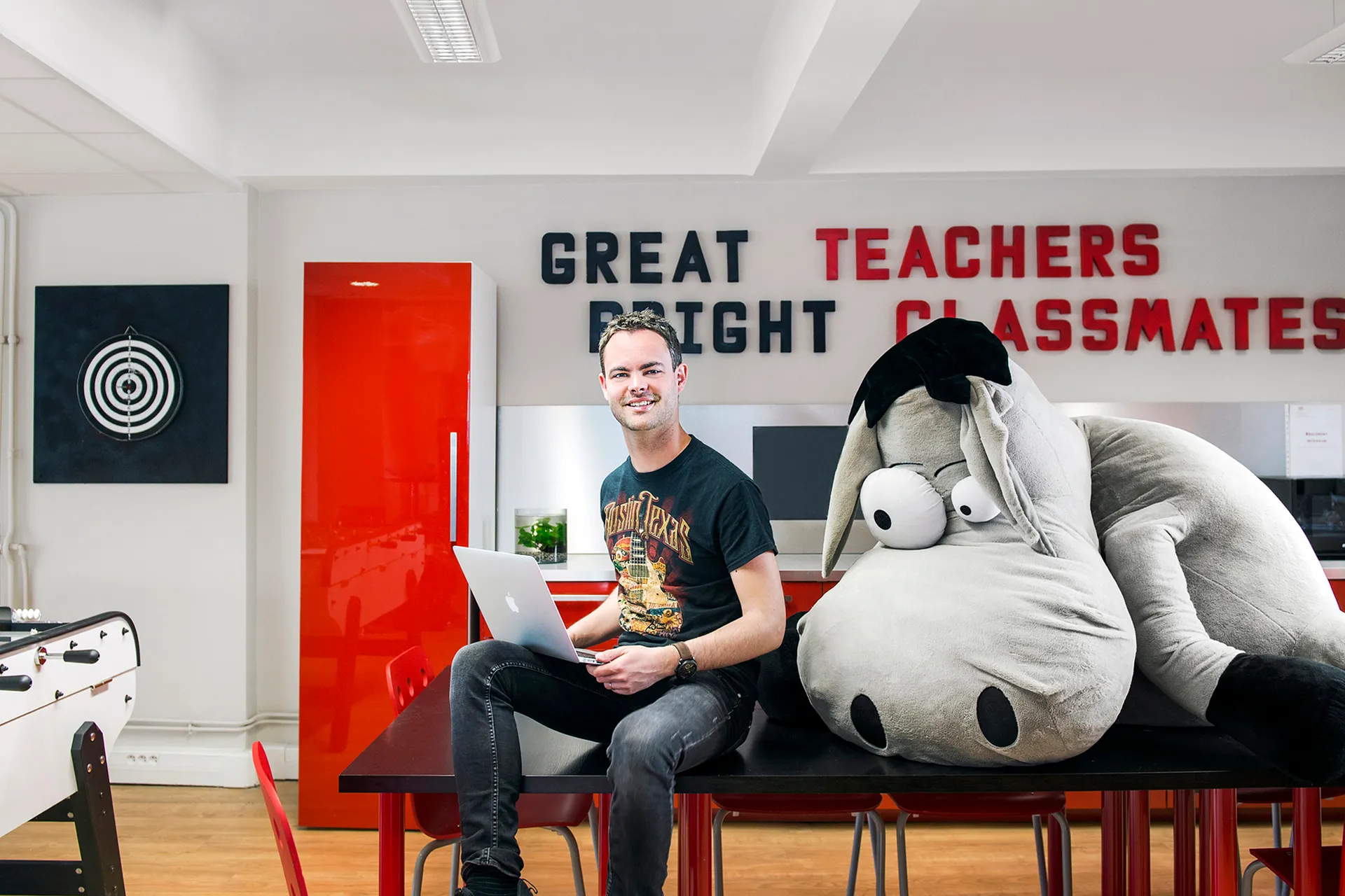 portrait d'un collaborateur, son laptop et sa peluche d'âne géante