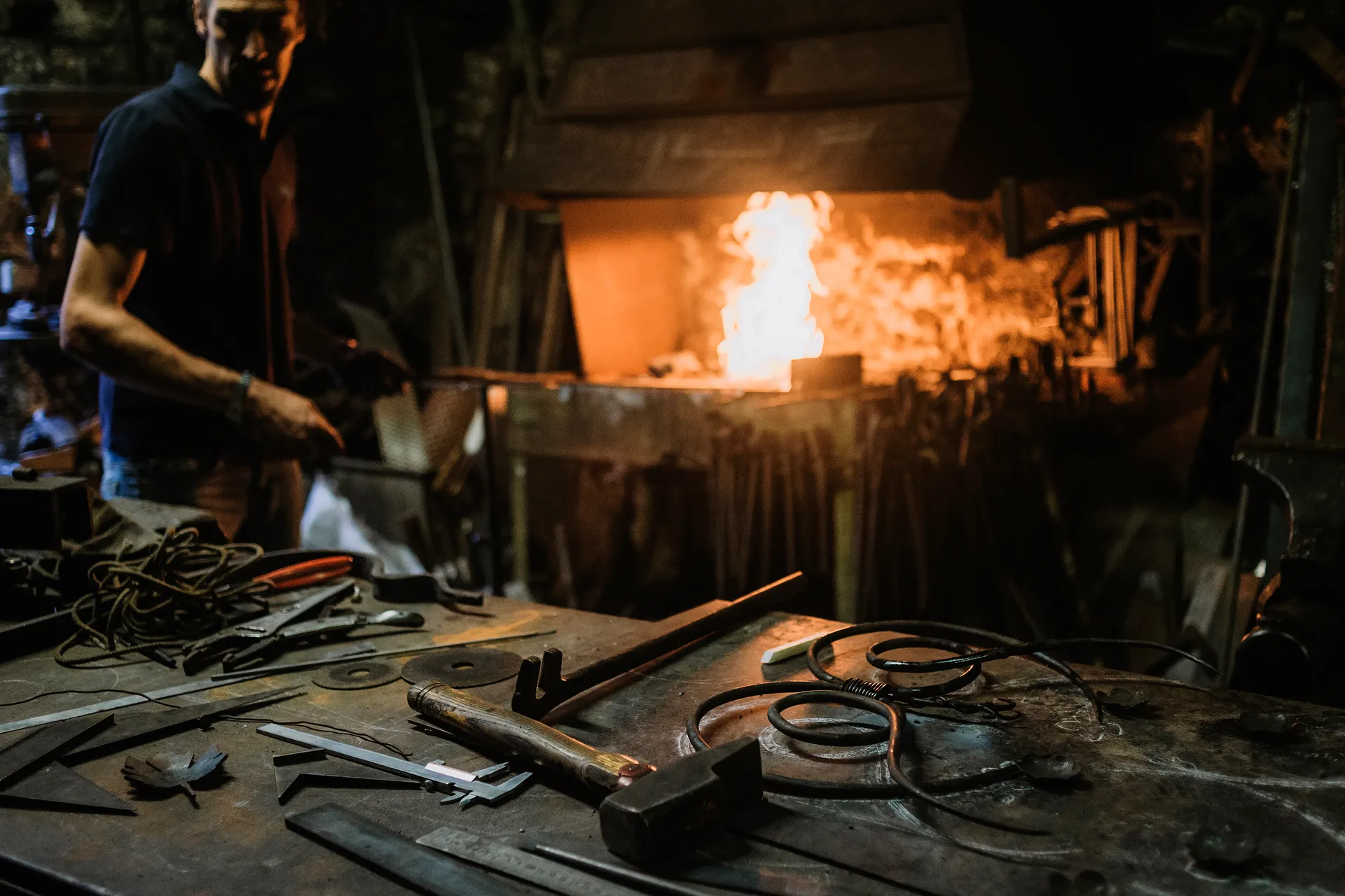 outils et ferronerie sur un établi devant le feu
