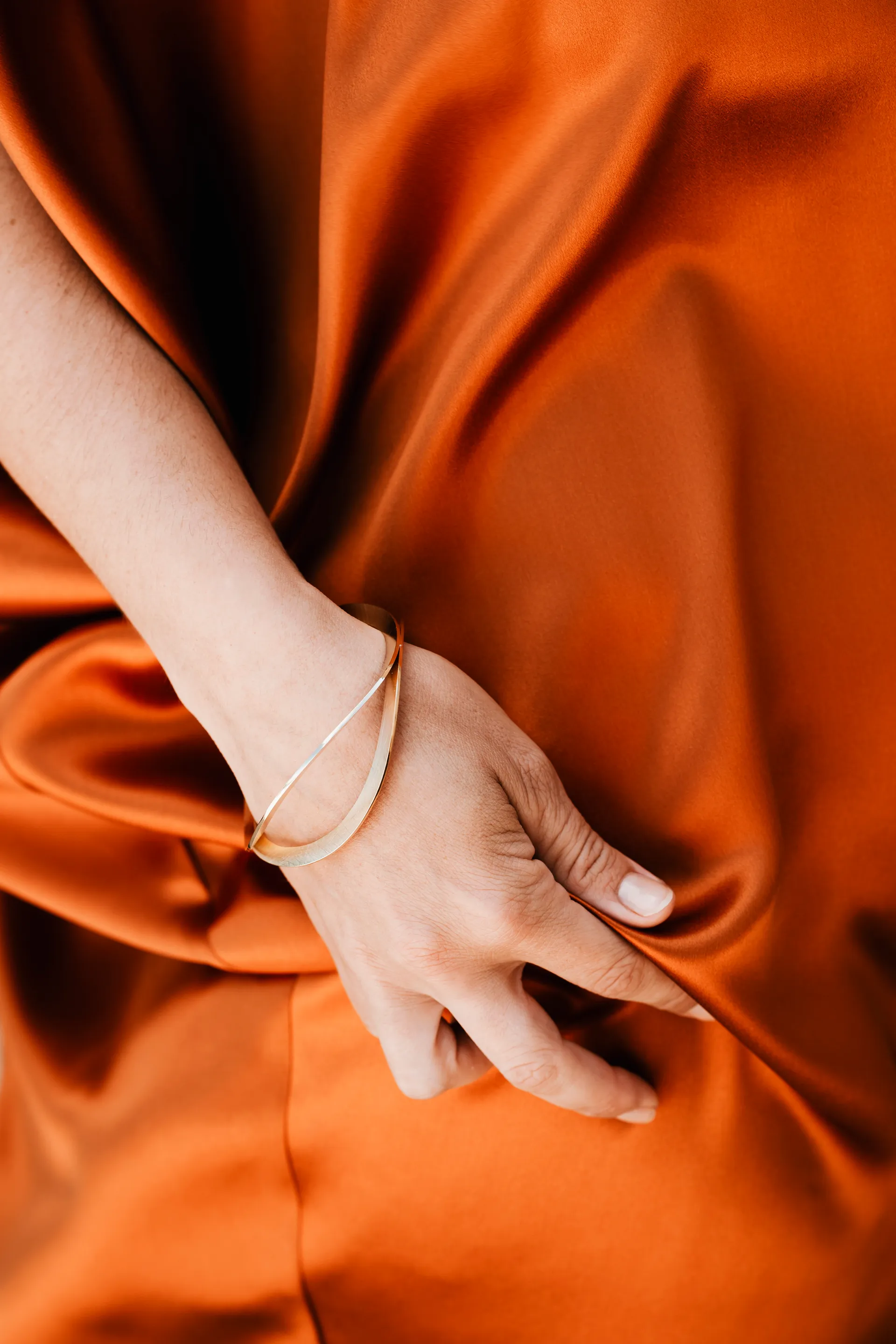 bracelet d'or sur un drapé orange