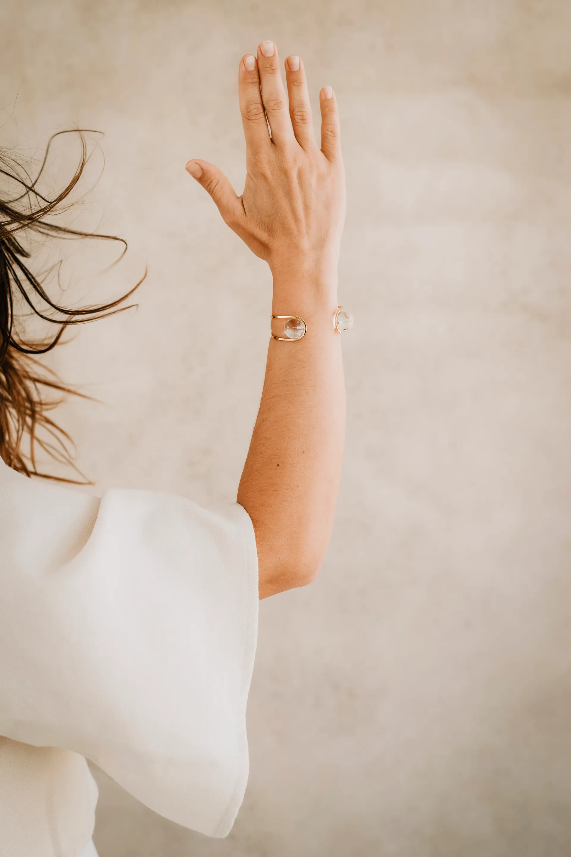 un bracelet au bras d'une femme en robe blanche