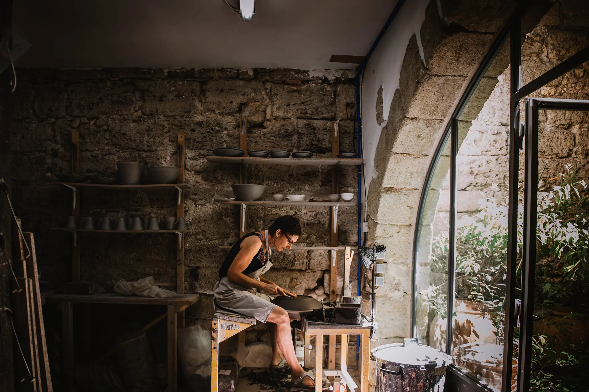 la céramiste travaillant à son tour de poterie au milieu de son atelier