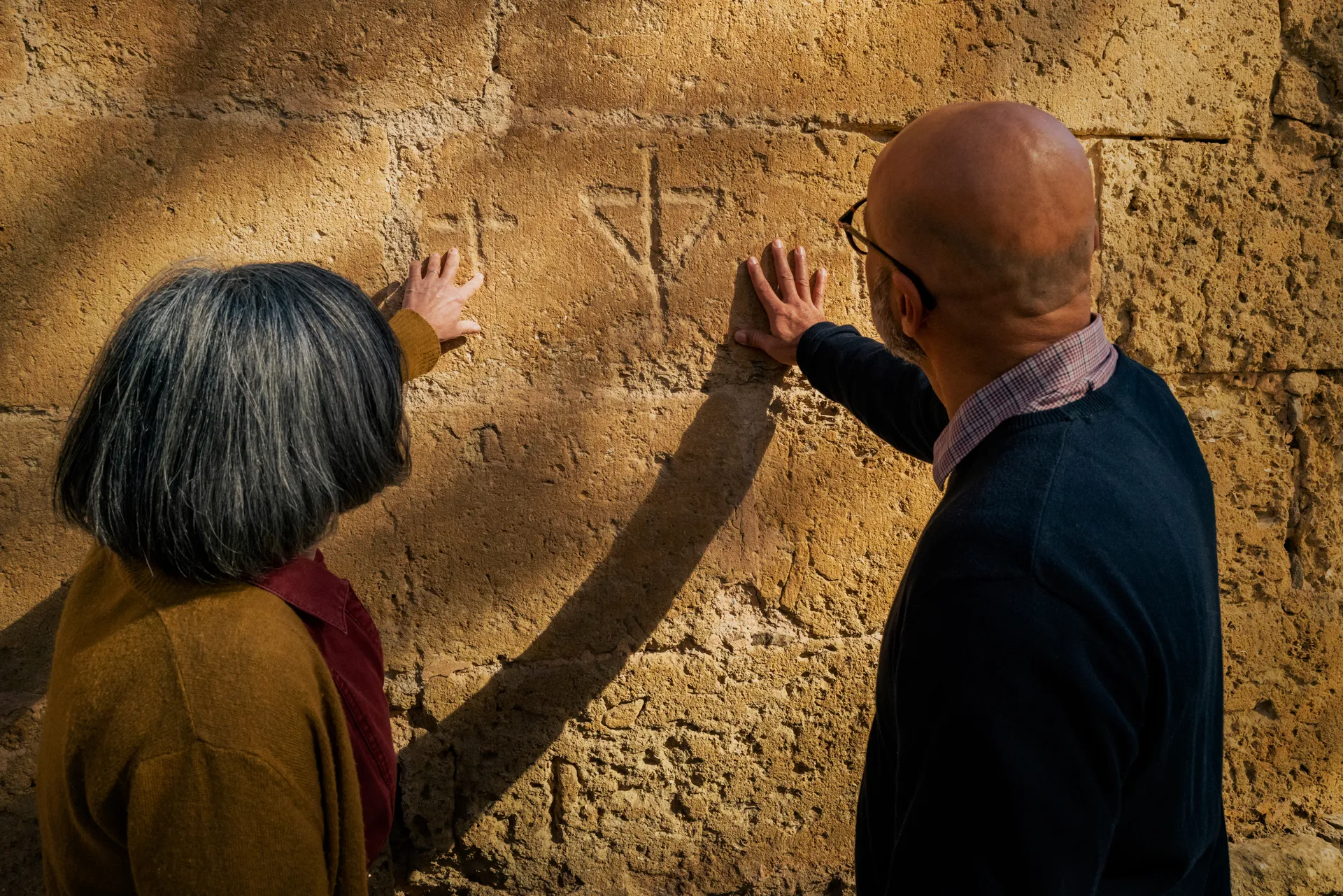un couple touche les pierres de l'abbaye de Valmagne