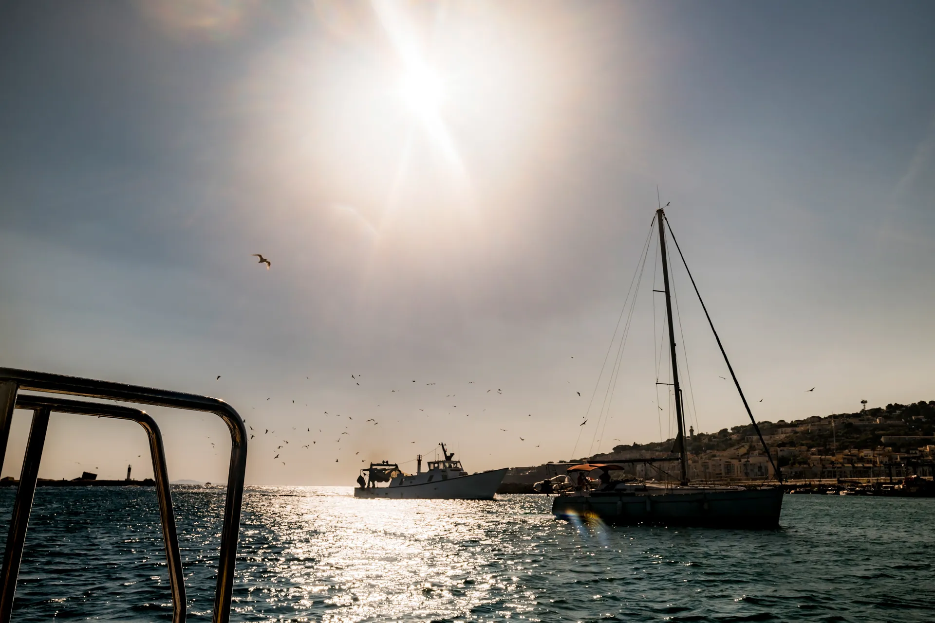 bateaux au soleil couchant à l'entrée du port de Sète