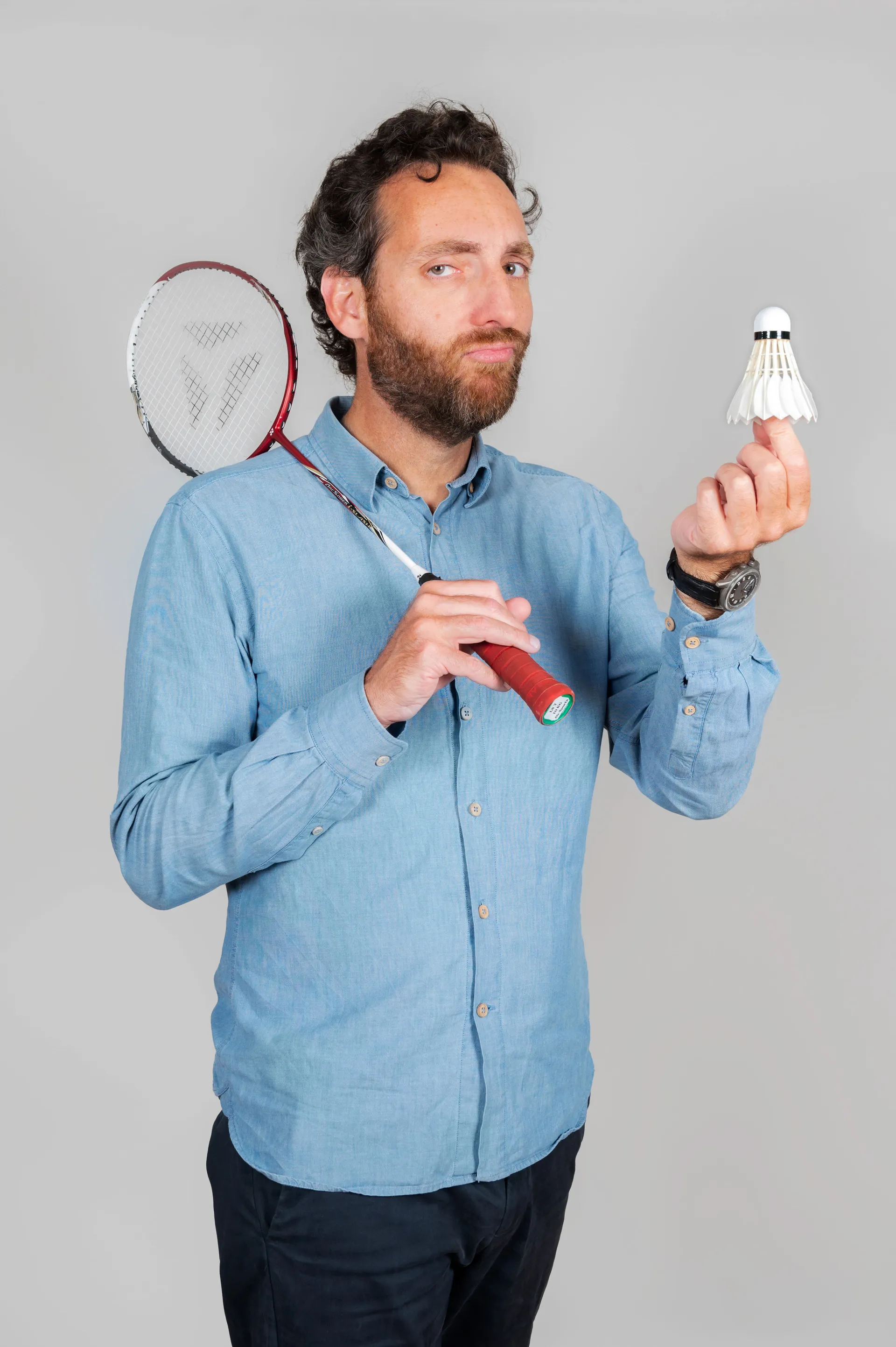 portrait studio d'un homme avec une raquette et un volant de badminton